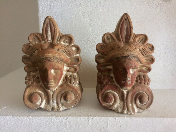 Dos apliques ornamentales de estilo antiguo, con diseños intrincados y una estética clásica.
