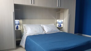 Ein Schlafzimmer mit einem Bett, Nachttischen und einer Lampe.