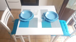 Ett vitt bord med blå tallrikar och ett glas, placerat på en blå och vit duk.