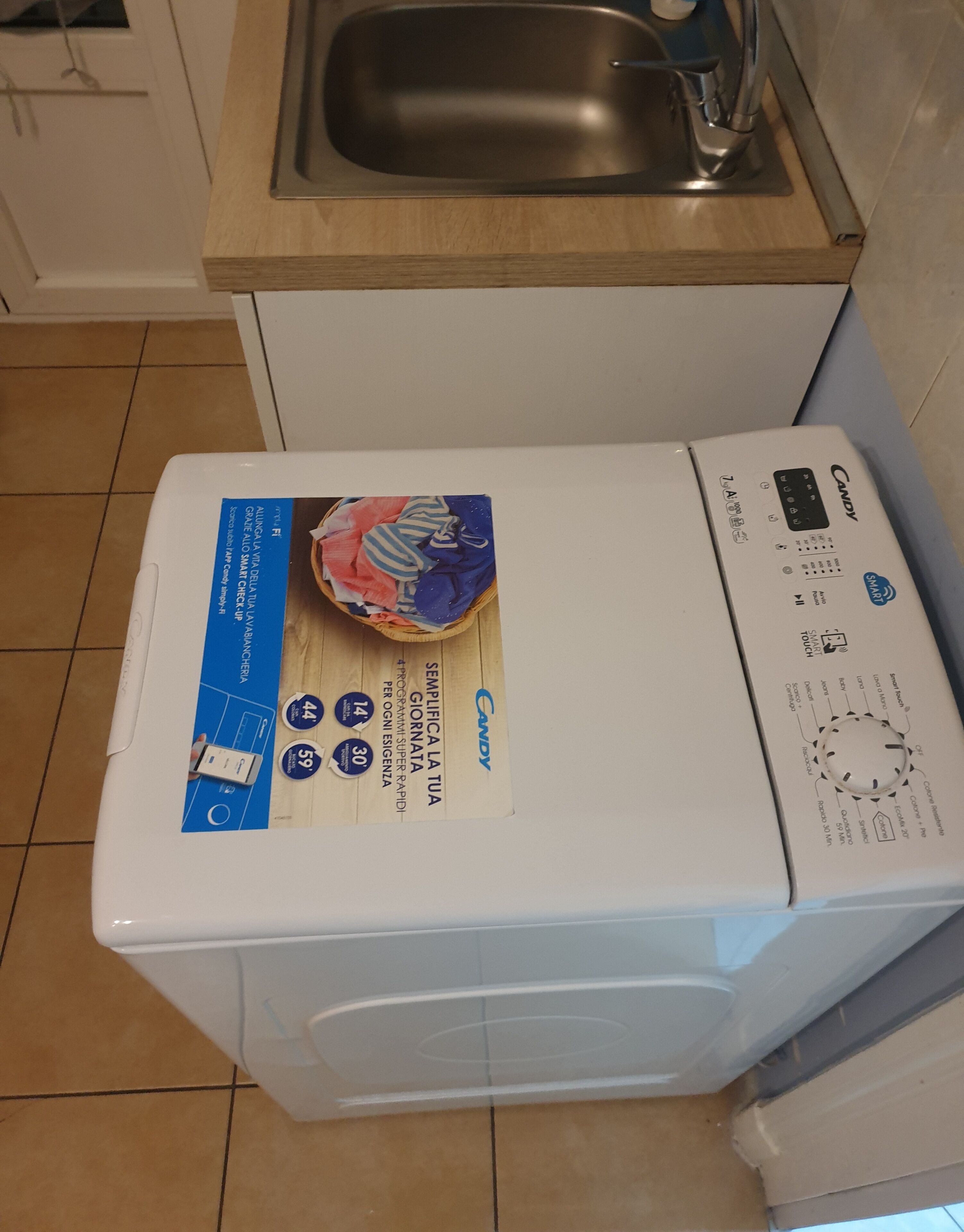 Eine Waschmaschine mit Frontlader, einer Bedienblende und einem Dosierfach für Waschmittel.