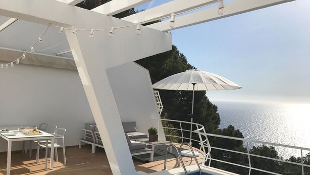 A pool area with a view of the sea, a table with chairs, and an umbrella. - Holiday rental semidetached with swimming pool in Begur, Sa Tuna (Begur)