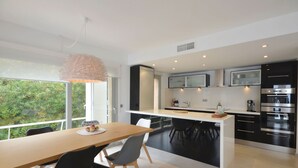 A modern kitchen with a central island, black cabinetry, and stainless steel appliances. - Holiday rental semidetached with swimming pool in Begur, Sa Tuna (Begur)