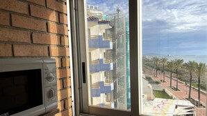 Une vue par une fenêtre, avec un mur de briques et un four à micro-ondes sur la gauche.