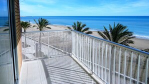 Un balcon avec vue sur la plage et l’océan.