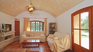 A living room with a fireplace, two sofas, a coffee table, and a television. - Moli - Rural house with pool in Búger (Buger)