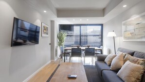 Una sala de estar moderna con un sofá, una mesa de centro y un comedor con sillas y una mesa.