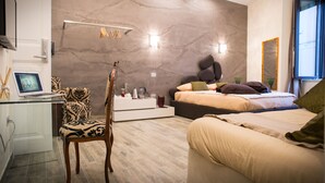 Une chambre à coucher moderne avec un lit, un bureau avec un ordinateur portable, une chaise et une table de chevet.