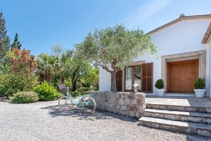 Une maison avec un mur en pierre, une porte en bois et des marches menant à l’entrée.