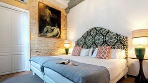 Une chambre à coucher avec un lit, un tableau, une tête de lit à motifs et deux lampes.
