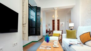 Un salon moderne avec un canapé, une table basse et un téléviseur fixé au mur.