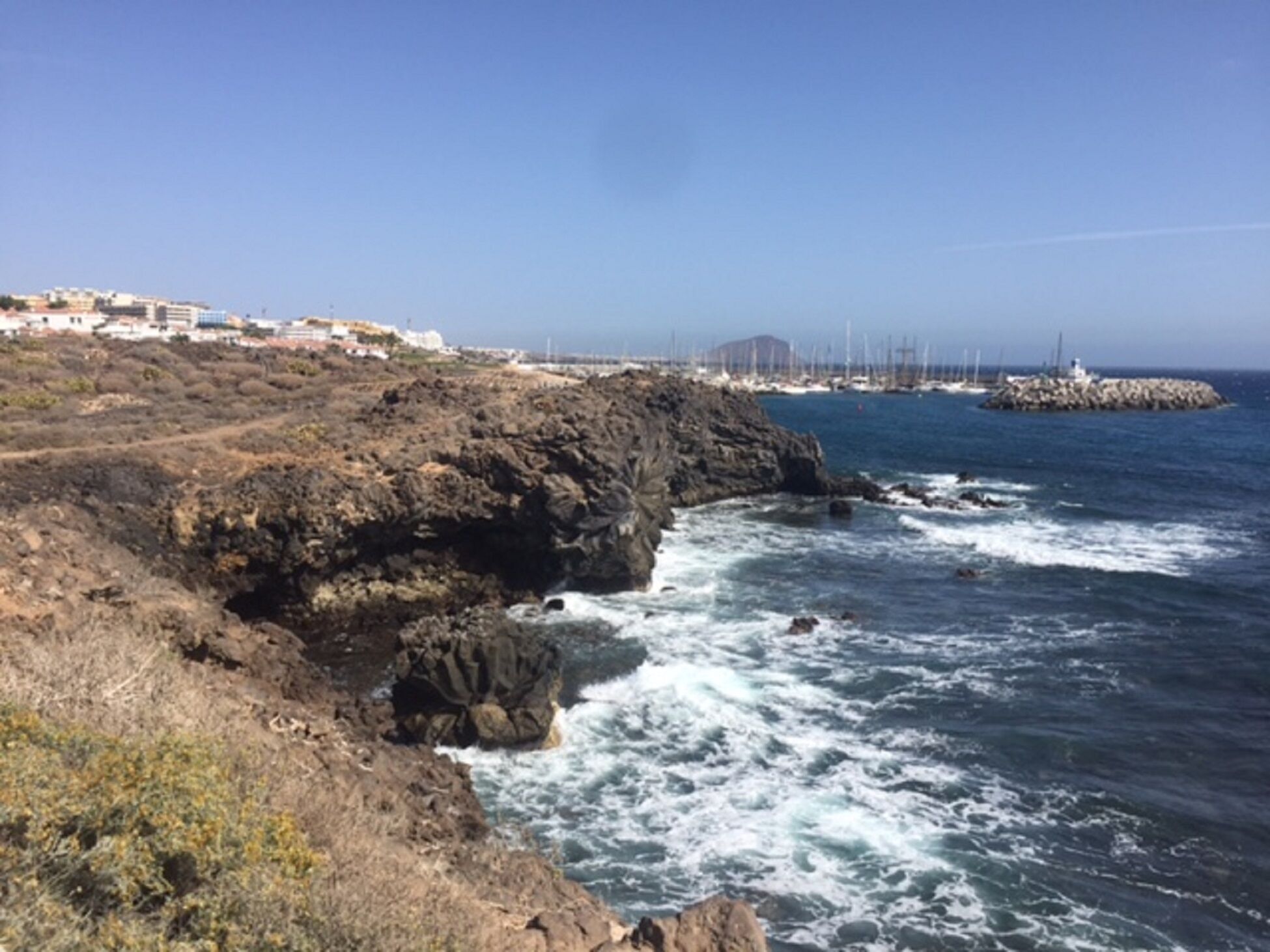 A coastal landscape with rocky terrain and a view of the ocean.