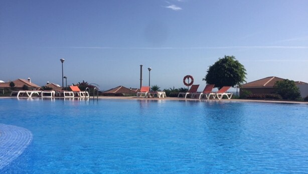 A swimming pool with lounge chairs and a lifebuoy.