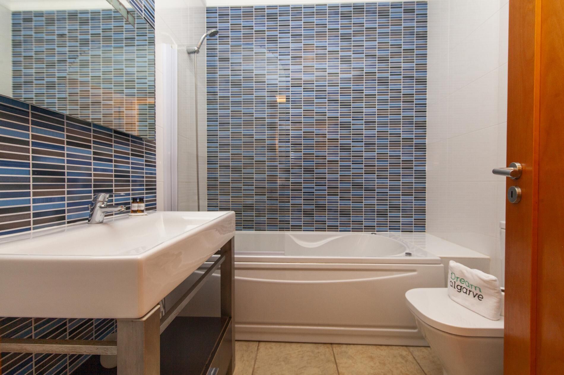 A bathroom with a bathtub, a toilet, and a sink.