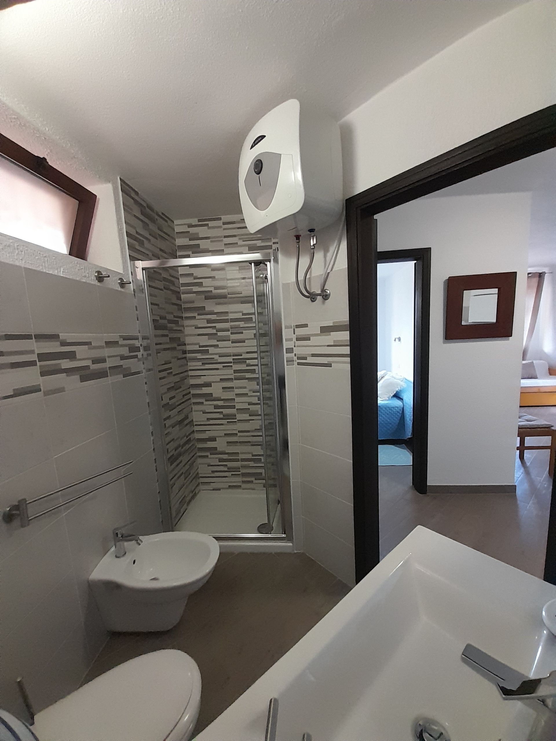 Uma casa de banho com chuveiro, sanita e banheira.