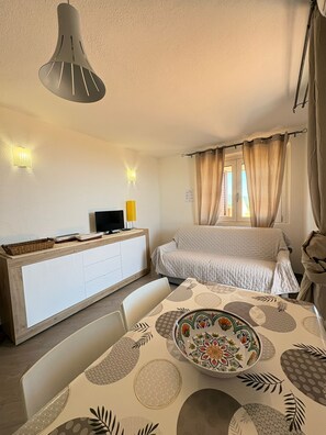Une chambre Ă coucher comprenant un lit, un bureau, une chaise et une table ornĂ©e dâune assiette dĂ©corative.