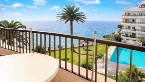 A balcony with a view of the sea, a pool, and a well-maintained lawn. - Acapulco Playa 308 by Casasol (Nerja)