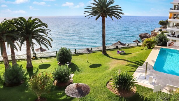 A pool area with a view of the sea, palm trees, and a white fence. - Acapulco Playa 308 by Casasol (Nerja)