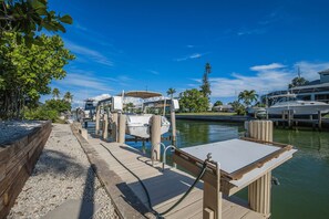 Stroll along the waterfront walkway to the marina, surrounded by lush greenery and palm trees.