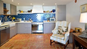 Une cuisine compacte équipée d’une cuisinière, d’un four, d’un four à micro-ondes et de divers ustensiles.