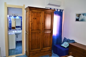 Casa de banho com armário de madeira, pia e espelho.