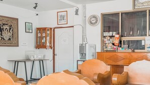 A room with wooden furniture, a white door, and a window with a clock. - Jitrawadee Hotel (Lampang)