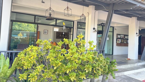 A modern building with large windows, a reception desk, and hanging pendant lights. - Jitrawadee Hotel (Lampang)