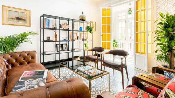A living room with a leather sofa, a black bookshelf, and a wooden coffee table. - Genteel Home Romanilla (Granada)