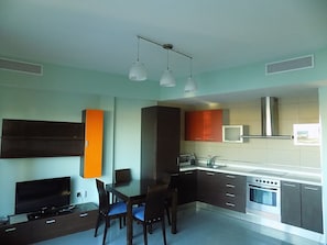A modern kitchen with a dining area, built-in appliances, and pendant lighting.