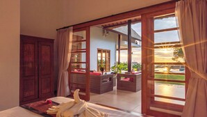 A room with a bed, a balcony with wicker furniture, and a view of the outdoors. - Luxury villa close to Lovina with pool and staff and spectacular views! (Temukus/Lovina)