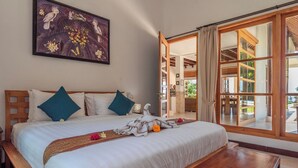 A bedroom with a large bed, wooden headboard, and a view through a glass door to an outdoor area. - Luxury villa close to Lovina with pool and staff and spectacular views! (Temukus/Lovina)