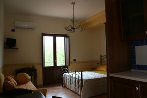 A bedroom with a bed, a desk, a chair, a window, and a ceiling fan. - Villa Rosi - Monolcale with pool (laureana cilento)