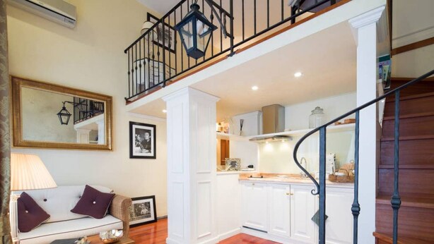 A living room with a sofa, coffee table, and a staircase leading to a second floor.