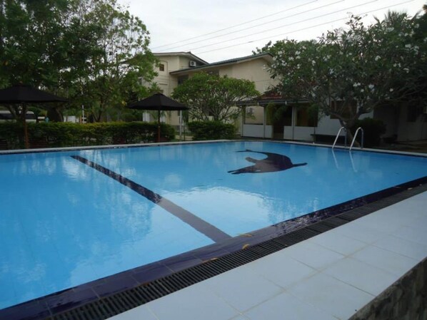 A swimming pool with a lifeguard chair and a diving board.