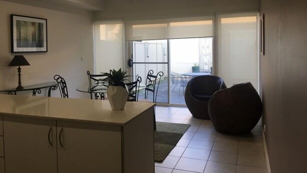 Eine moderne Küche mit Essbereich, großem Fenster und Ausblick nach draußen.