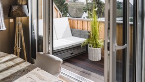A modern room with a wooden floor, a white sofa, a lamp, and a potted plant. - 5 star luxury apartment m. daily cleaning, fireplace u. great water view (Loddin)