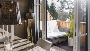 A cozy room with a wooden table, a white sofa, a wicker lamp, and a view of the outdoors. - 5 star luxury apartment m. daily cleaning, fireplace u. great water view (Loddin)