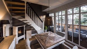 A modern interior with a staircase, a fireplace, a dining area, and large windows. - 5 star luxury apartment m. daily cleaning, fireplace u. great water view (Loddin)
