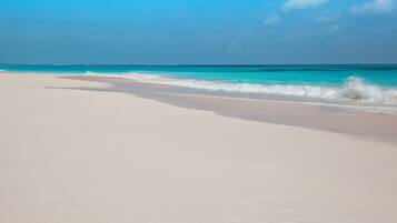 Rannalla, aurinkotuoleja, rantapyyhkeitä