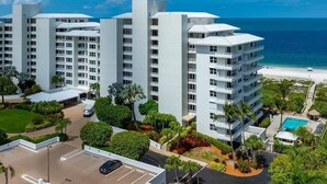 Ein Hochhotel mit zahlreichen Balkonen, einem Poolbereich und Blick auf den Strand.