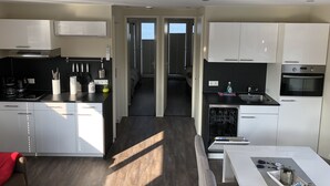 Una cocina moderna con armarios blancos, horno integrado y lavavajillas.