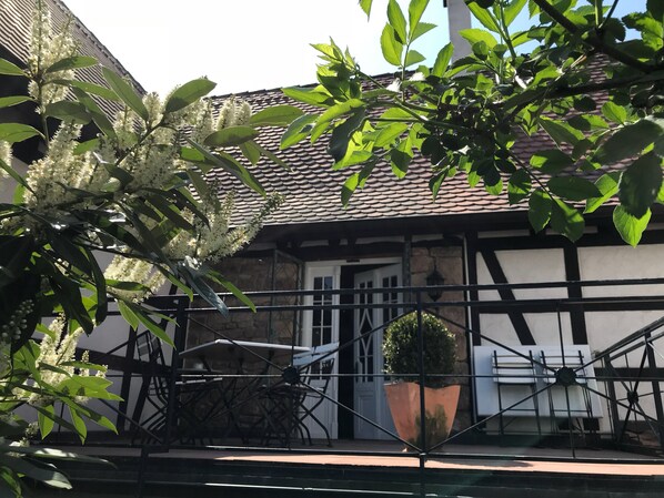 Ein traditionelles Gebäude mit einem Ziegeldach, einer Steinmauer und einem schwarzen Metallgeländer.