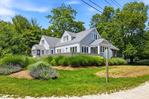 A large, two-story house with a prominent front porch and a well-maintained lawn.