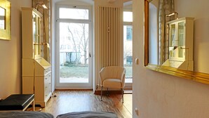Une chambre à coucher comprenant un lit, une chaise, une armoire et un grand miroir.