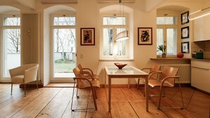 Une cuisine moderne avec une table à manger, des chaises et de grandes fenêtres.