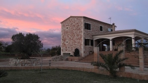 A stone house with a patio and a small garden. - Wonderful finca with a large pool and barbecue kitchen near Es Trenc!  (Campos)