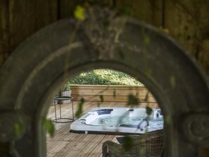 A wooden deck with a hot tub and a wooden planter with green foliage. - Le Pigeonnier Colbert (Rouvray)