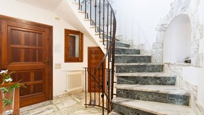 Eine Treppe mit Marmorstufen und einer Holztür.