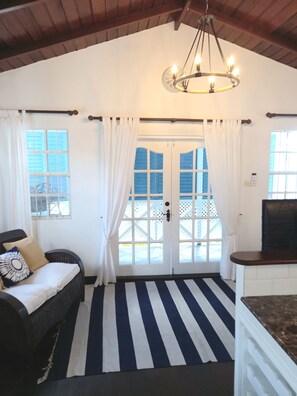 Enjoy a spacious room with a high ceiling, chandelier, and comfortable seating area.