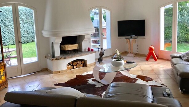 A living room with a fireplace, a television, and a sofa. - Beautiful, quiet villa in a beautiful village in the south of France (La Colle-sur-Loup)