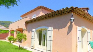 A two-story building with a tiled roof, white shutters, and a small garden area. - Beautiful, quiet villa in a beautiful village in the south of France (La Colle-sur-Loup)
